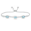 Thumbnail Image 0 of Sideways Oval Swiss Blue Topaz and Lab-Created White Sapphire Frame Three Stone Bolo Bracelet in Sterling Silver - 9.5"