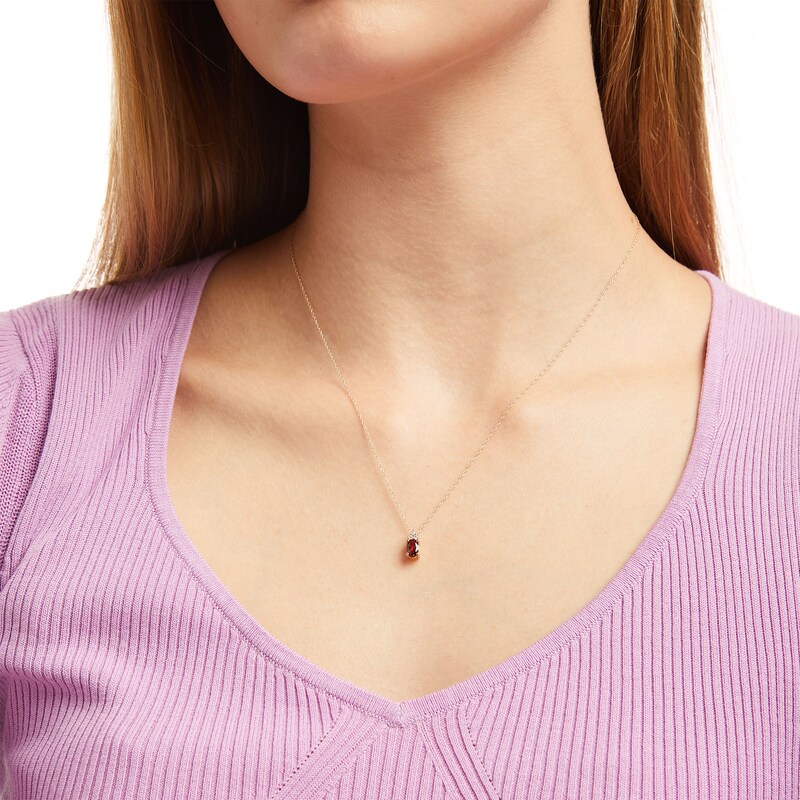 Oval Garnet and 1/20 CT. T.W. Diamond Pendant in 10K Gold