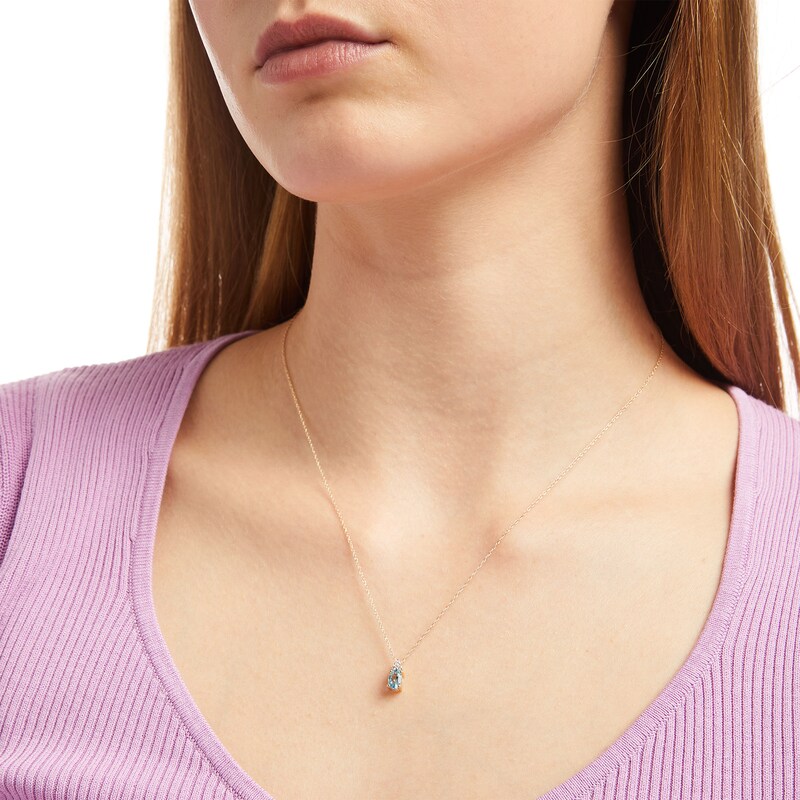 Oval Swiss Blue Topaz and 1/20 CT. T.W. Diamond Pendant in 10K Gold