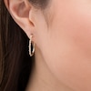 Thumbnail Image 1 of Previously Owned - 1/10 CT. T.W. Diamond Twist Oval Hoop Earrings in 10K Gold