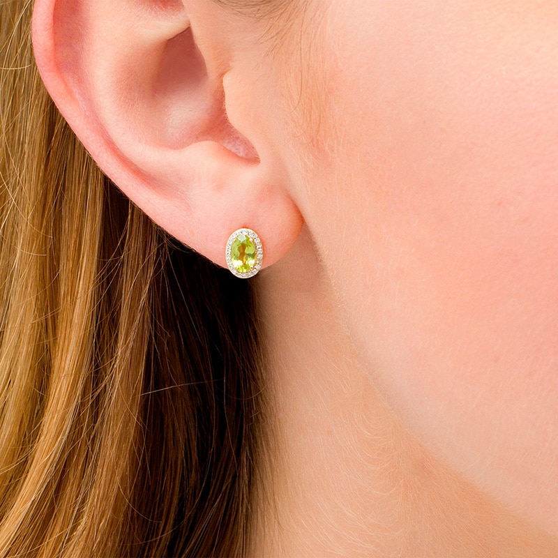 Previously Owned - Oval Peridot and 1/10 CT. T.W. Diamond Frame Stud Earrings in 10K Gold
