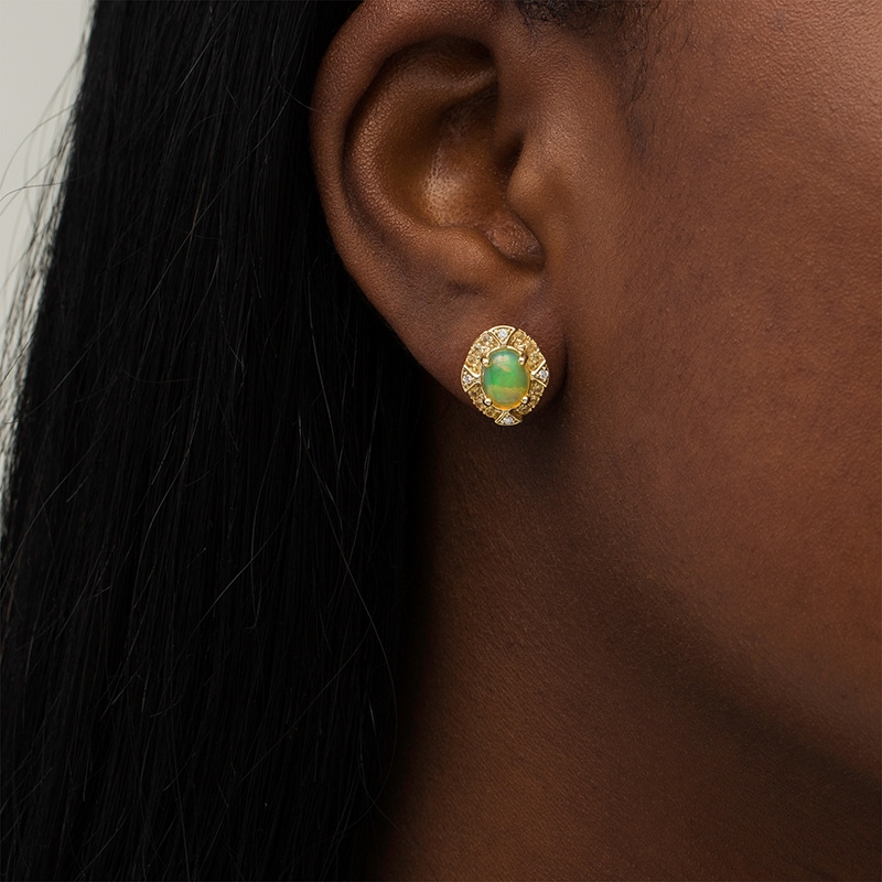 Previously Owned - Captivating Color Oval Opal, Spessartite and 1/20 CT. T.W. Diamond Frame Stud Earrings in 14K Gold
